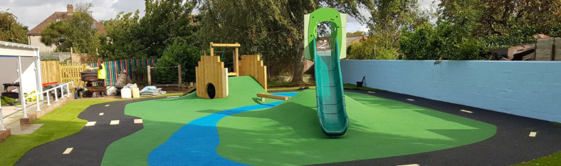 A rubber crumb race course forms a central island featuring children's play equipment