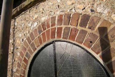 Photograph showing arched brickwork around a window after repair.