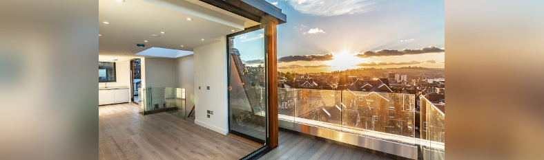 Sunset from the penthouse suite balcony with bifold doors open, bringing outside spaces in.