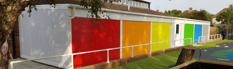 Six garages with colourful painted shutters provide secure outside storage space